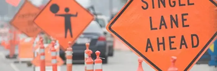 Construction signs and channelizing cones in a live work zone