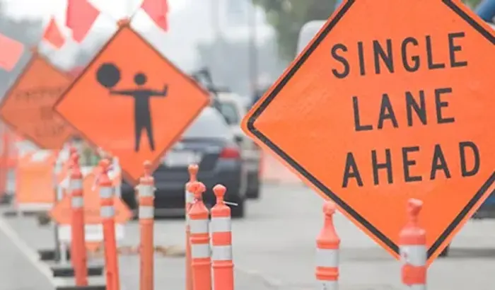 Traffic cones and construction signs staged in a work zone