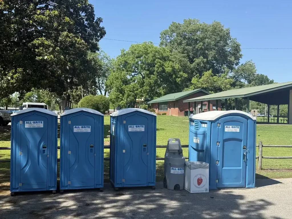 Portable toilets and hand-wash station at a community park event