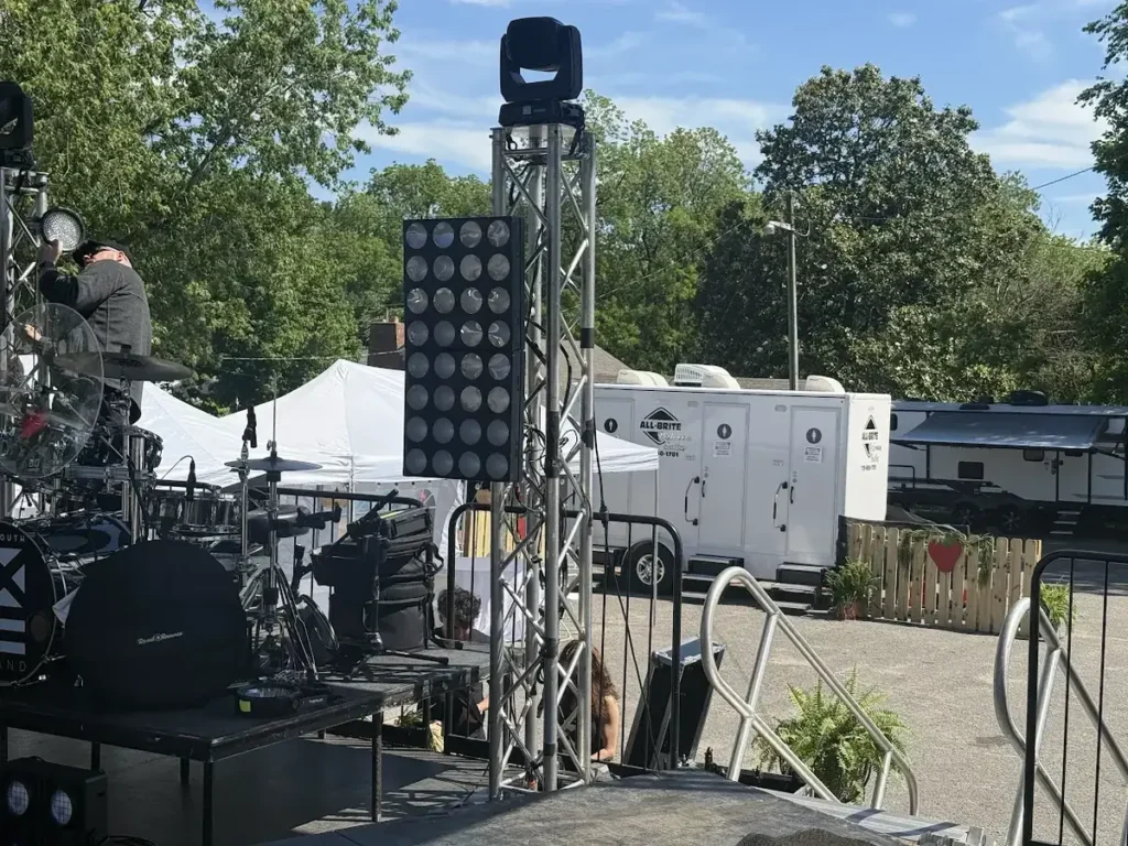 Restroom trailers positioned behind the stage at an outdoor concert